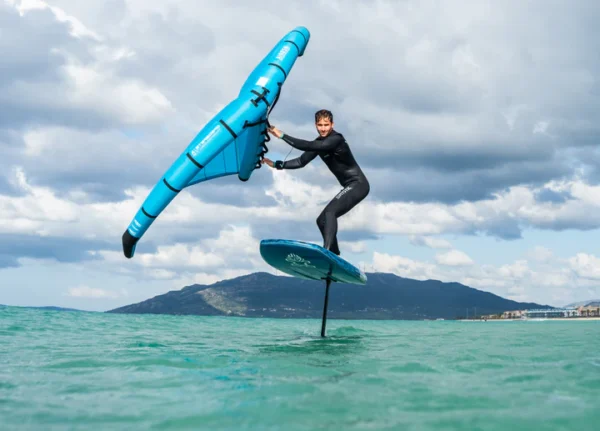 Žmogus laikantis Starboard x Airush FreeWing Air V1 ant vėjo