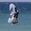 lycra-anti-uv-homme-bleu-manche-longue-wingfoil-saintjacques-wetsuits_1 Athlete wearing Long Sleeve Lycra top while stand-up paddleboarding